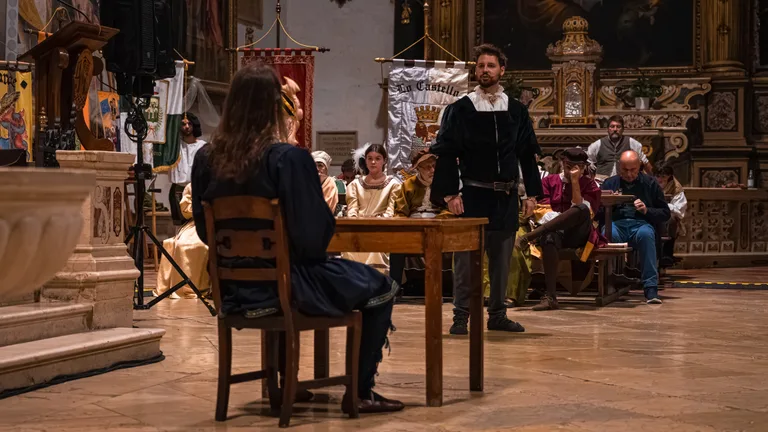Scena dello spettacolo con gli attori in costume e i gonfaloni delle contrade